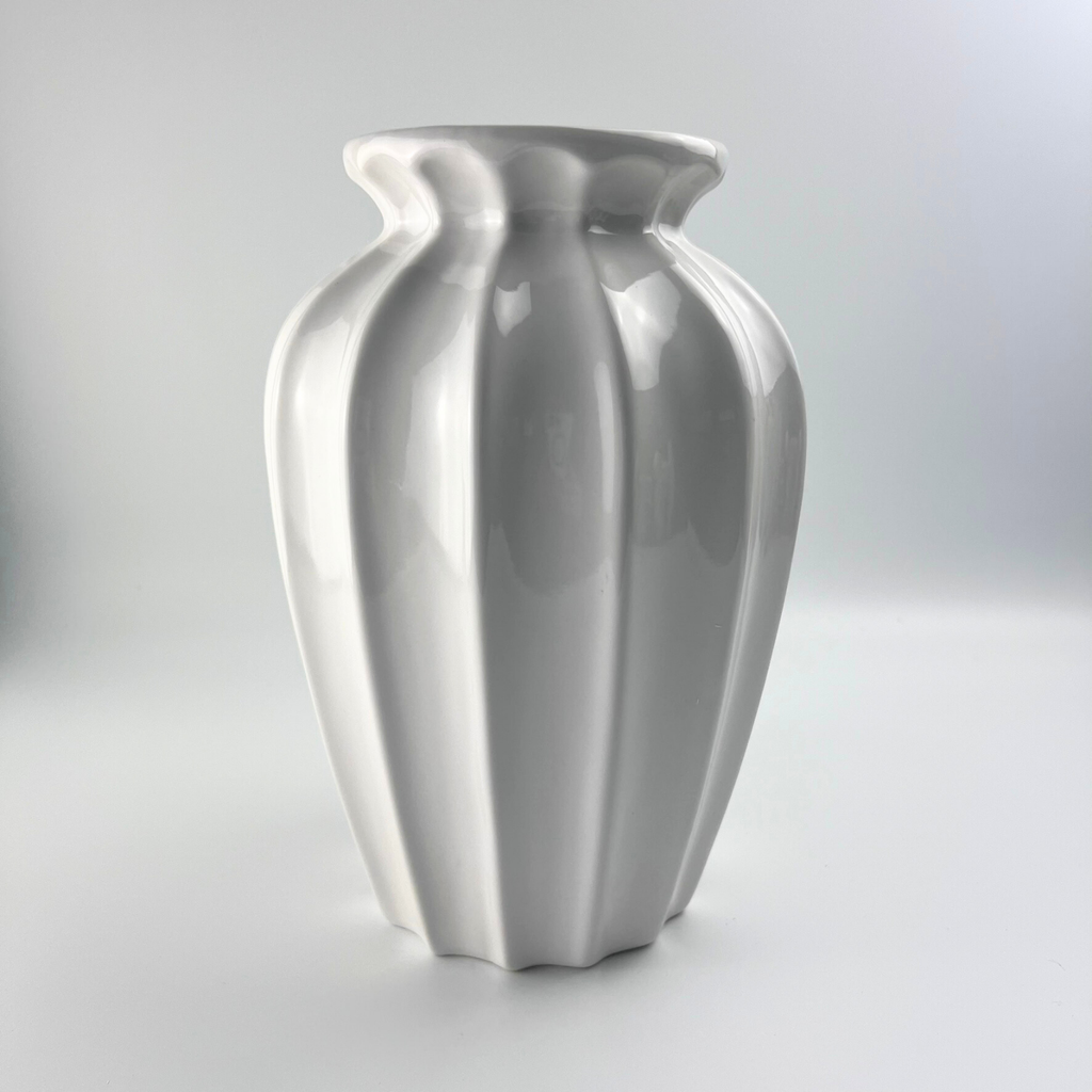 Close up of white glossy ceramic vase, featuring a unique appealing design 