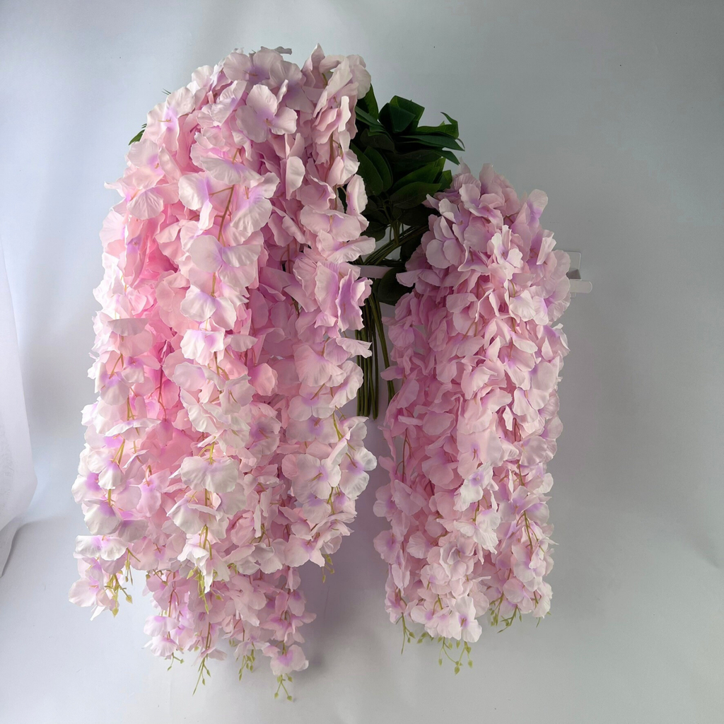 A bunch of 12 artificial Wisteria flower stems with 3 flowers per stem in a blush or light pink colour on a white background