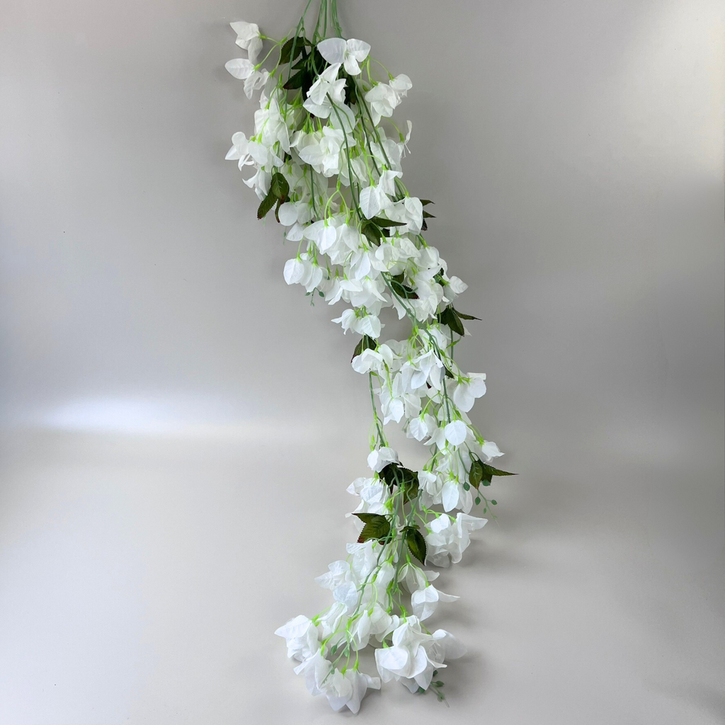 Artificial white Bougainvillea flower stem on a plain background