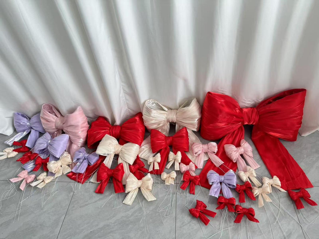 A selection of large decorative bows in red, pink, lilac and champagne in various sizes