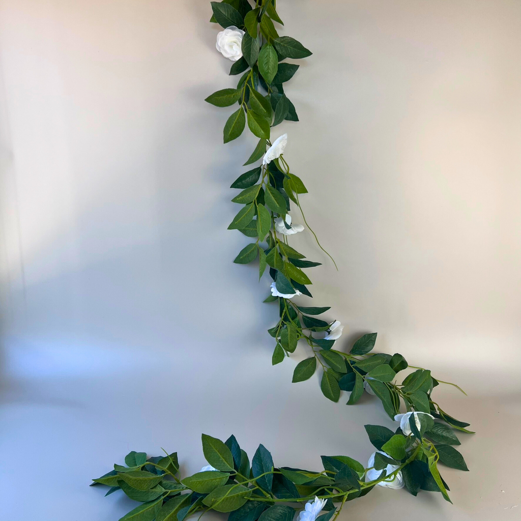 Long lush white camellia flower garland with beige background 