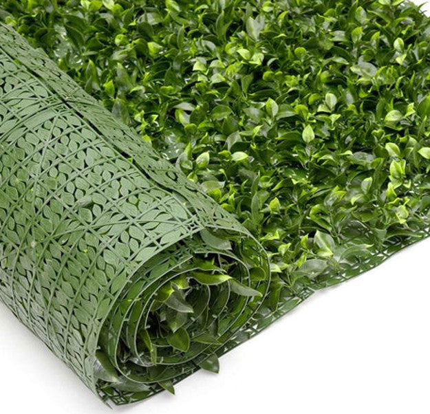 A rolled-up artificial green wall hedge, used to beautify and add privacy, featuring a dense foliage appearance.
