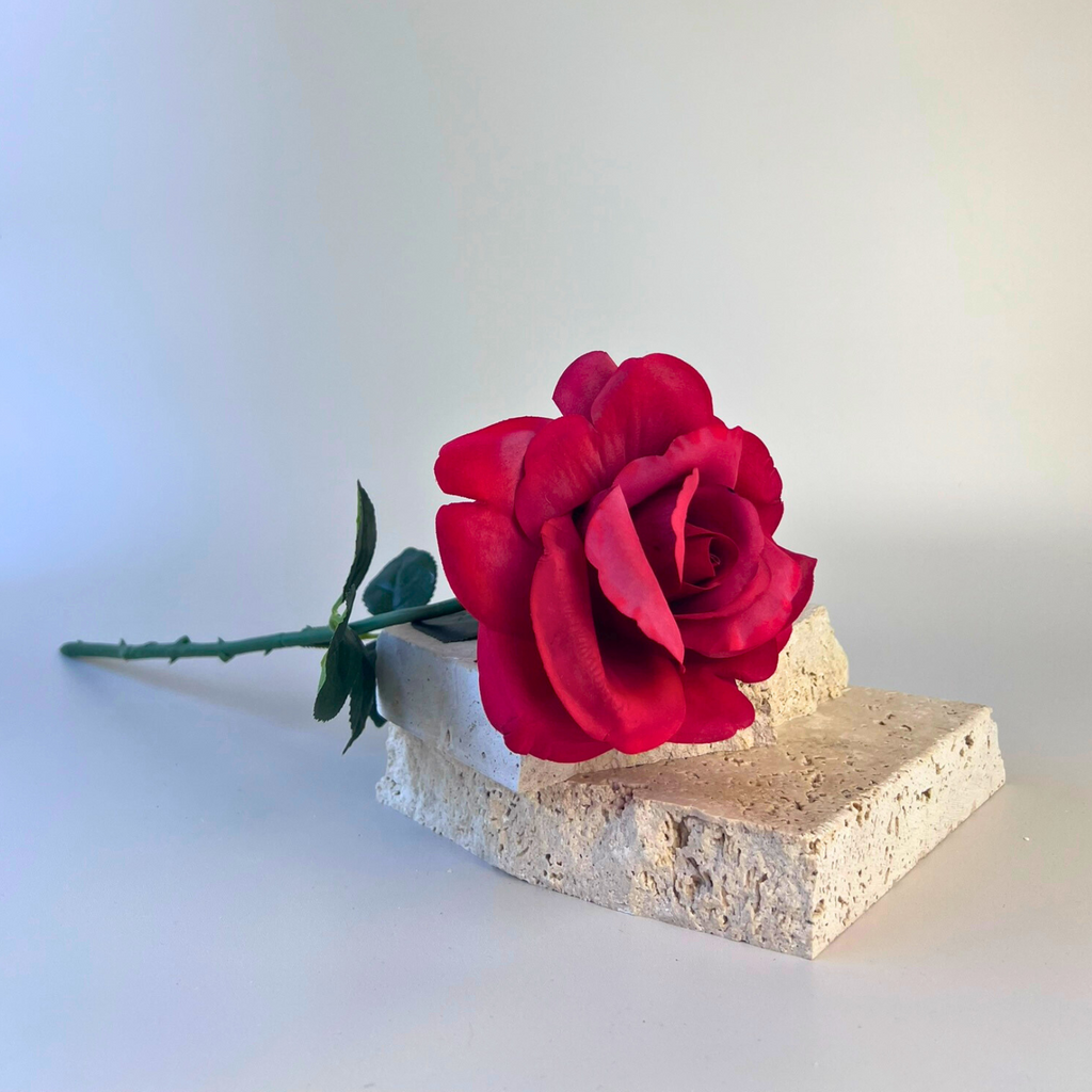 A classic artificial rose with soft and realistic petals in red