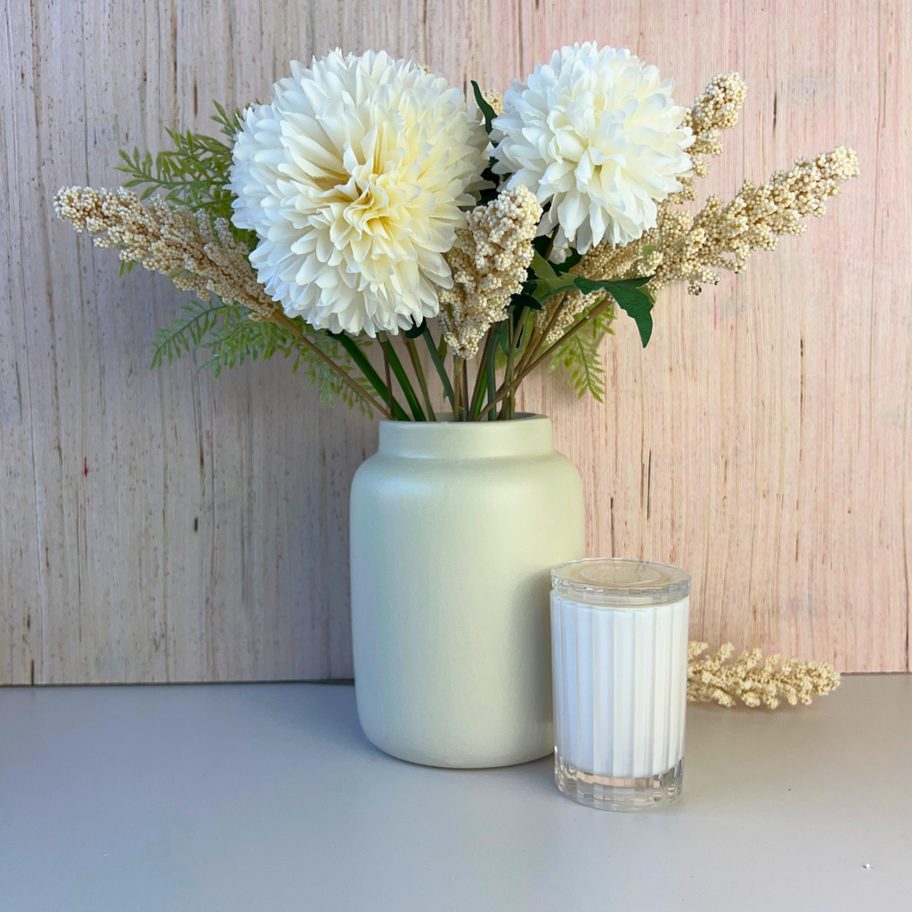 Styled Stone Ceramic vase next to candle with flower arrangement 