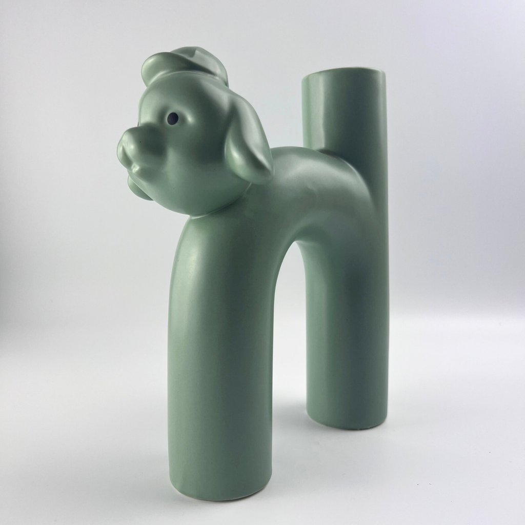 Green ceramic vase shaped like a dog on a white background