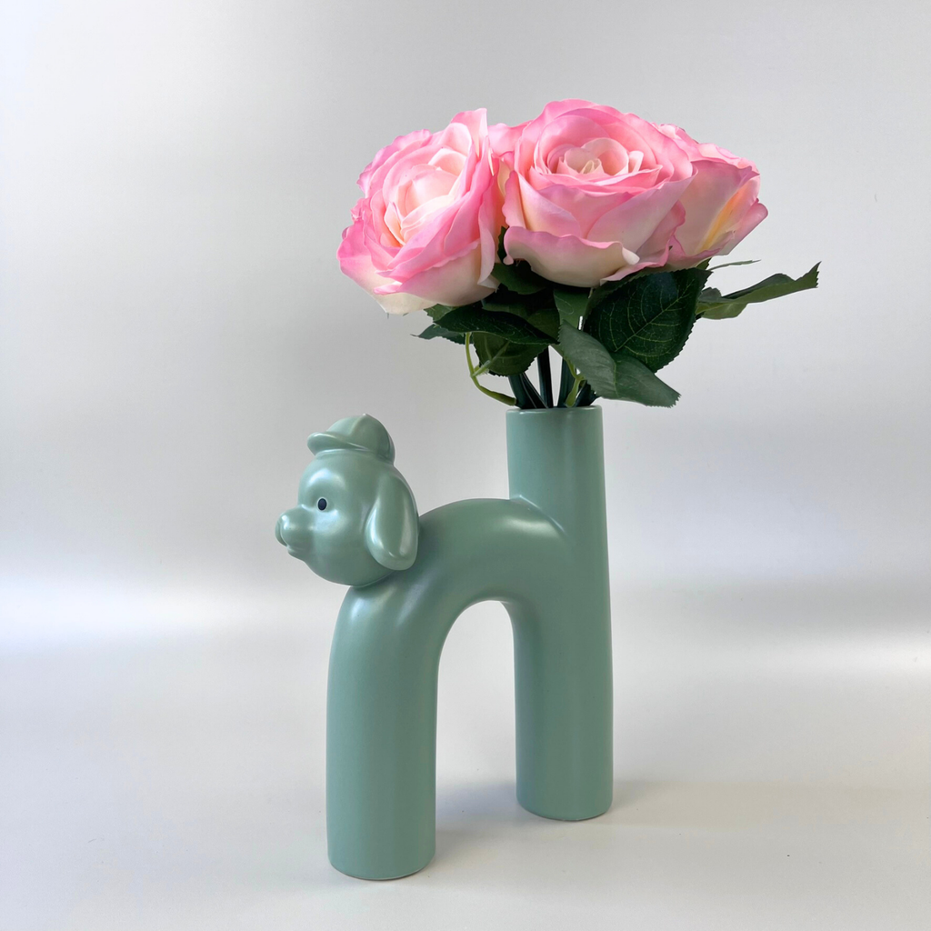 Green dog vase styled with a pink floral arrangement  