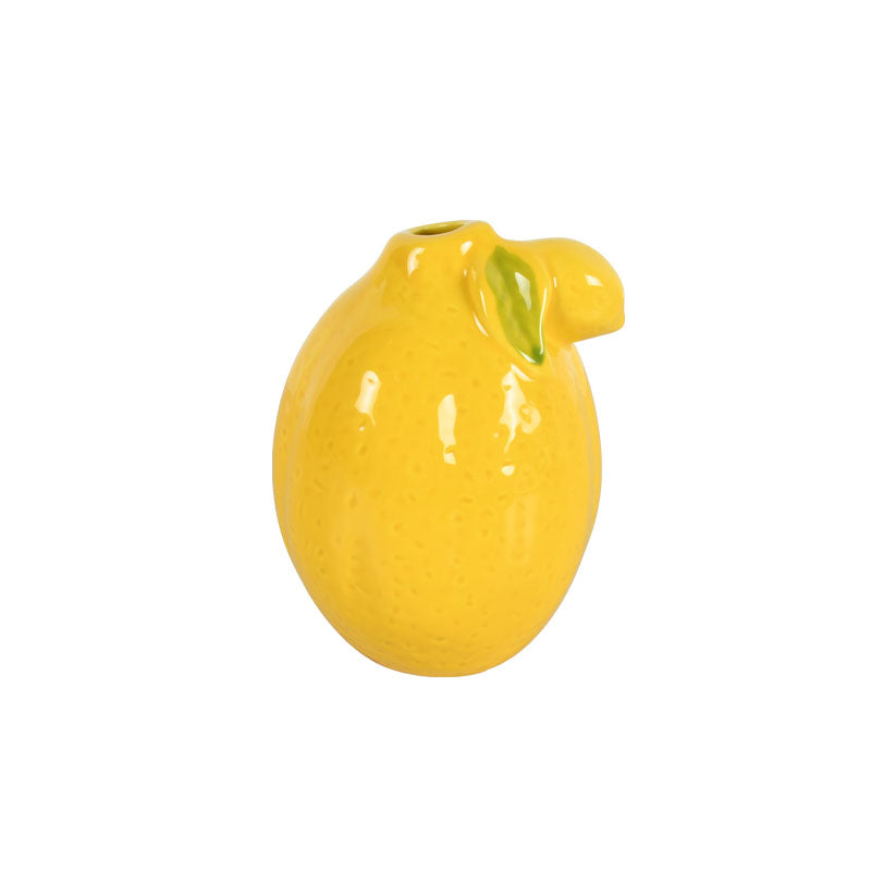 Bright yellow ceramic lemon-shaped vase against a white background